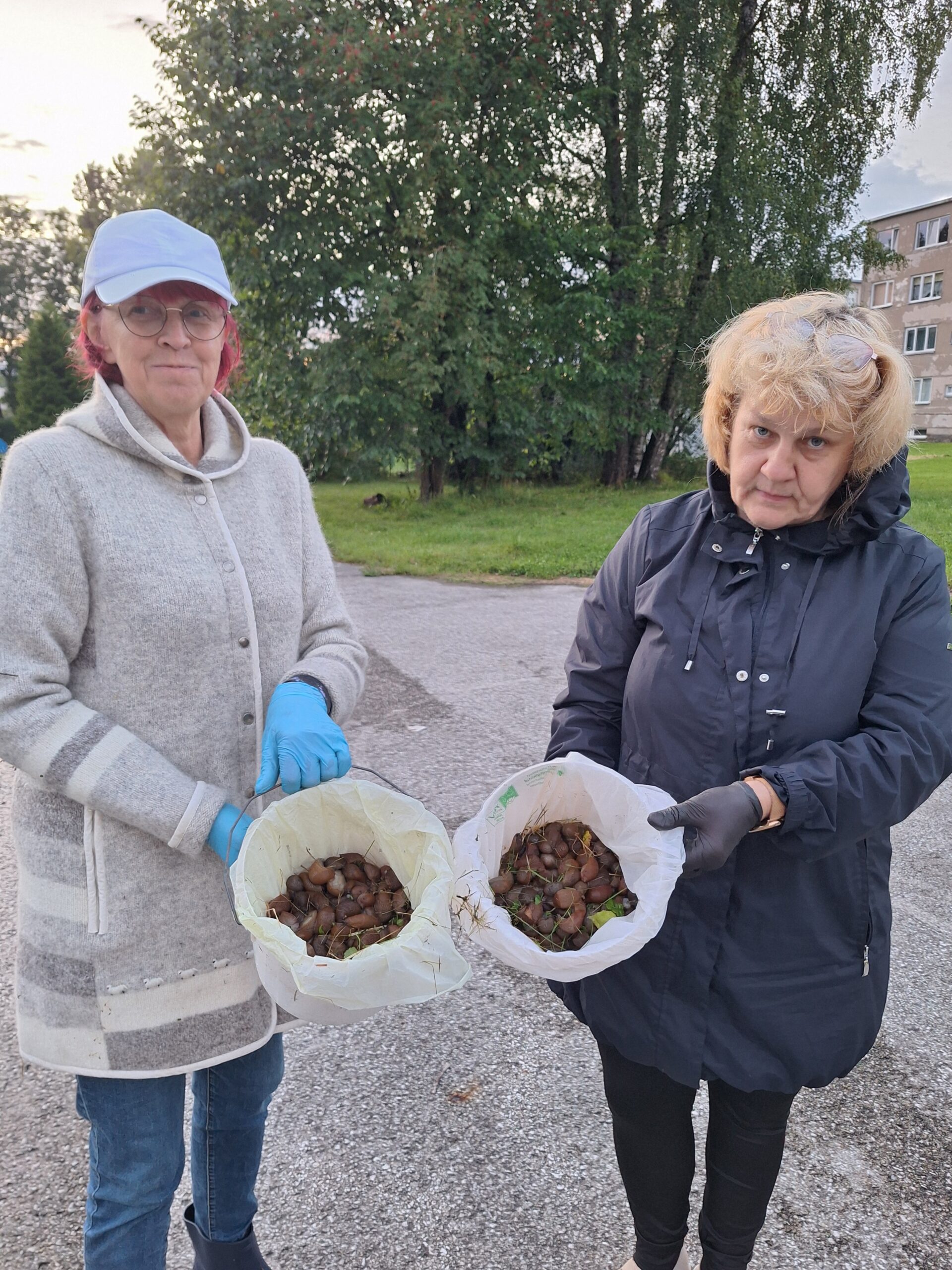 Reet Alev ja Evi rohtla näitavad napi tunniga Mari lasteaia platsilt kogutud nälkjaid. Foto Samuel Axel Maikalu